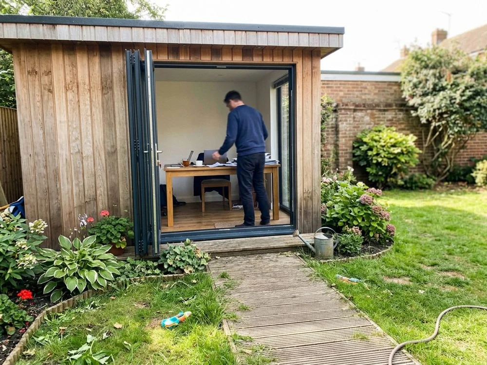 Cedar-clad garden office with bifold doors in a Bedford garden